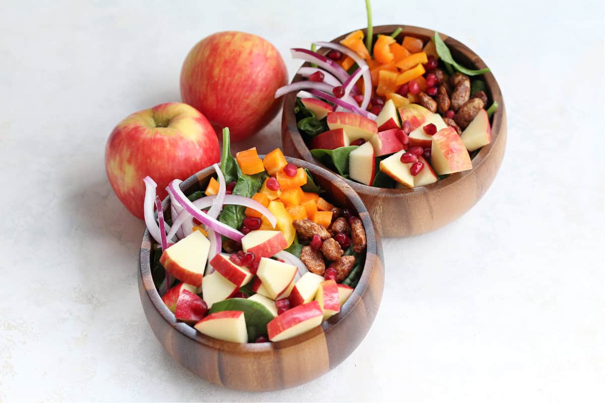 Tasty Apple Spinach Harvest Salad Tasty Apple Spinach Harvest bowls and two Honeycrisp apples.
