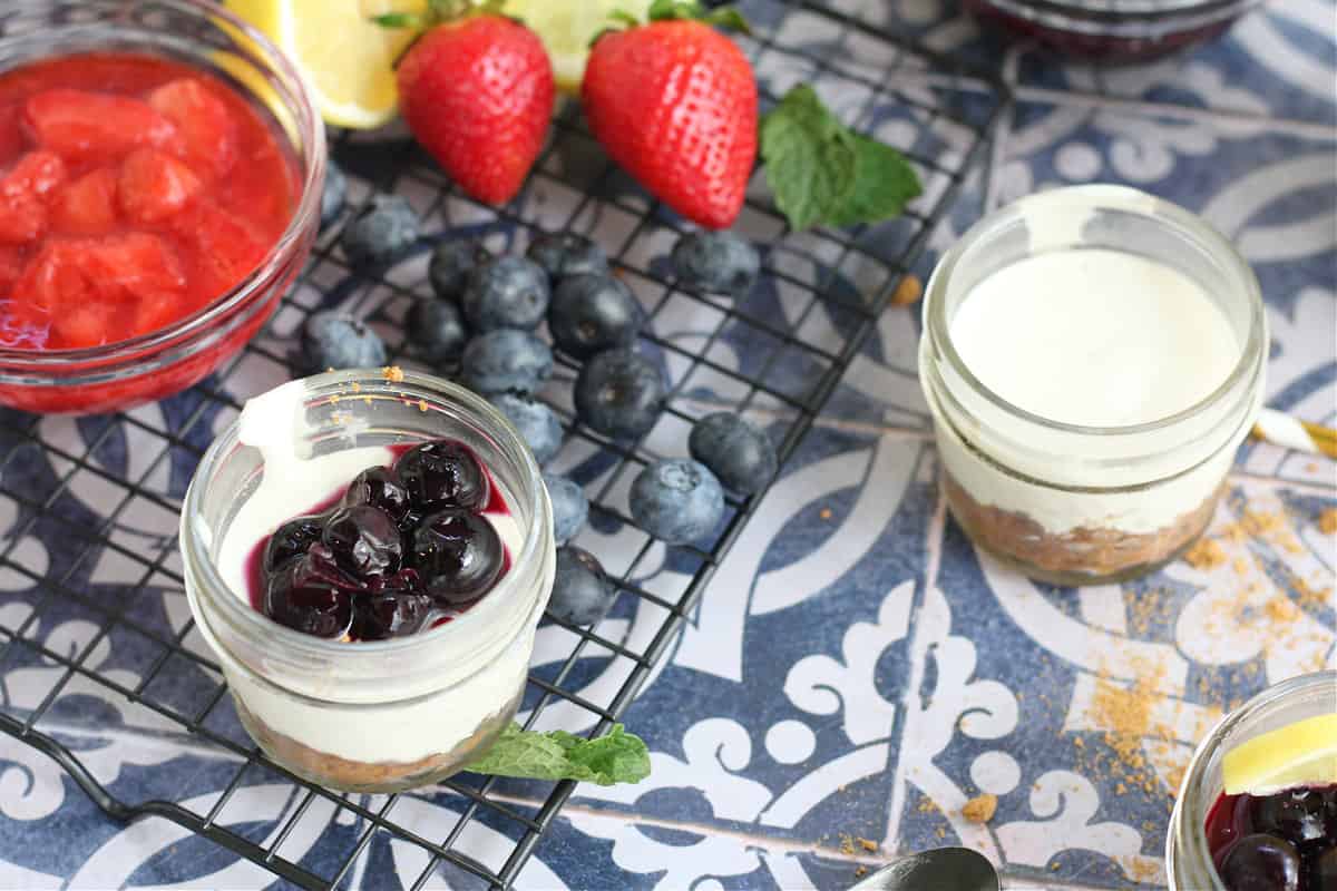 Healthy No Bake Cheesecakes in mason jars with fruit topping Healthy No Bake Cheesecakes in mason jars with fruit topping