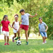 Cute children playing football in park