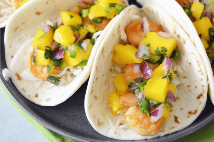 Shrimp tacos with citrusy and crunchy toppings. An ideal recipe for a Cinco de Mayo celebration.